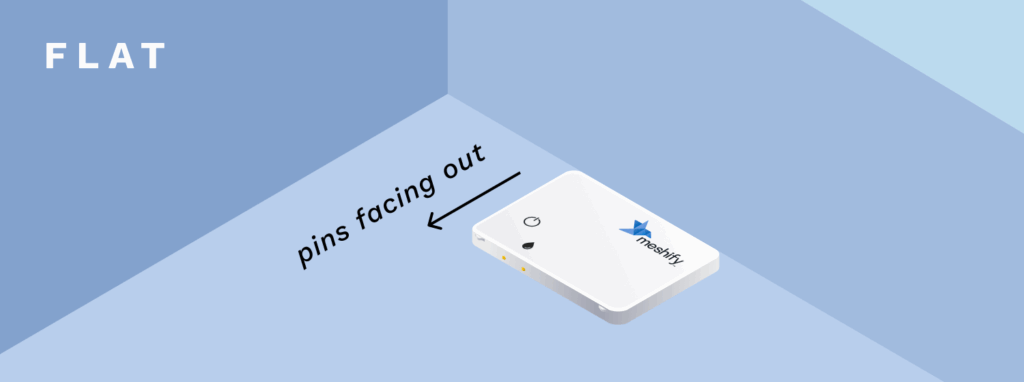 An illustration of the Defender Slim sensor being placed flat on the ground with the pins on the sensor being faced away from the wall.